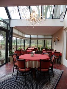 een restaurant met rode tafels en stoelen en een kroonluchter bij Wildenborcherhof in Vorden