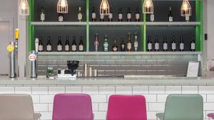a bar with purple chairs and bottles of wine at Holiday Inn Express Aberdeen Airport by IHG in Dyce