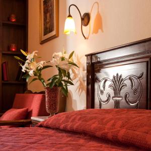 Un dormitorio con una cama roja con un jarrón de flores en Fretzato en Elati Trikalon