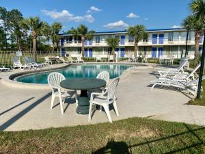 a patio with a table and chairs next to a pool at Motel 6 Marianna, FL in Marianna