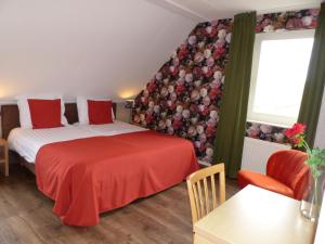 a hotel room with two beds and a table and chair at Wildenborcherhof in Vorden