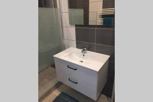 a bathroom with a white sink and a mirror at F2 agréable proche de toute commodité in Château-Thierry