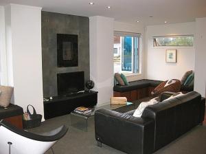 a living room with a couch and a fireplace at Les Fleurs avec Spa - Ohakune Holiday Home in Ohakune