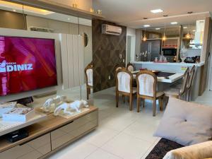 a living room with a tv and a dining room at Apartamento Moderno na Praia dos Ingleses in Florianópolis