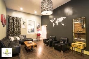 a living room with leather furniture and a map of the world on the wall at The Clarence Park in Toronto