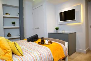1 dormitorio con 1 cama con mesa y TV en Trendy Urban Industrial Apartment - Great Location - Parking - Fast WiFi - Smart TV - Beautiful 2 Double Bedroom Apartment sleeps up to 4!, en Bournemouth