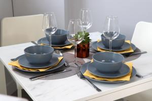 una mesa de comedor con platos azules y copas de vino en Trendy Urban Industrial Apartment - Great Location - Parking - Fast WiFi - Smart TV - Beautiful 2 Double Bedroom Apartment sleeps up to 4!, en Bournemouth