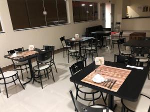 ein Restaurant mit Tischen und Stühlen in einem Raum in der Unterkunft Hotel Prata Express in Pratânia