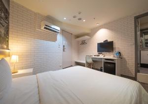 um quarto com uma cama e uma secretária com uma televisão em 9ine Hotel em Taipei