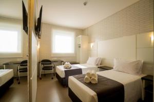 Postel nebo postele na pokoji v ubytování Hotel Confiance Barigui