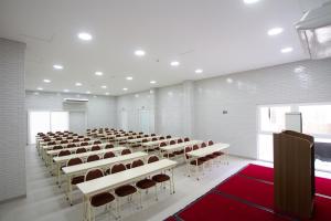 a large room with rows of tables and chairs at Hotel Confiance Barigui in Curitiba