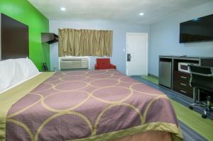 a hotel room with a large bed and a desk at Executive Inn Fort Stockton in Fort Stockton