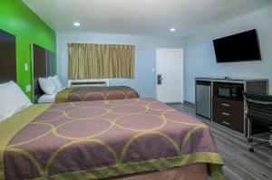 a hotel room with two beds and a flat screen tv at Executive Inn Fort Stockton in Fort Stockton