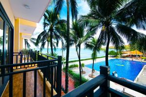 a resort balcony with a view of a pool and the ocean at Hon Rom Central Beach Resort in Mui Ne