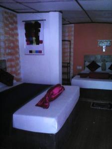 ein Schlafzimmer mit 2 Betten und einem roten Handtuch darauf in der Unterkunft Lotus Inn Tourist Resort in Dambulla