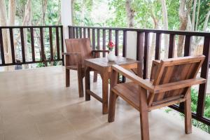 a wooden table and two chairs on a balcony at The C Samet Beach Resort SHA Plus in Ko Samed