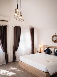 Un dormitorio con una gran cama blanca y una ventana en The C Samet Beach Resort SHA Plus, en Ko Samed