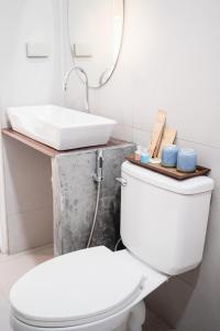 y baño con aseo blanco y lavamanos. en The C Samet Beach Resort SHA Plus, en Ko Samed