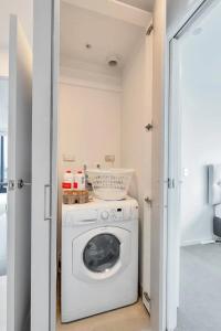 a laundry room with a washer and dryer at Amazing Harbour, Skytower and Rangitoto Views in Auckland