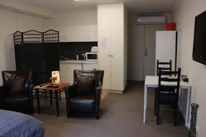 a room with a table and chairs and a kitchen at Box Hill Studio 3 at Canterbury Gardens in Box Hill