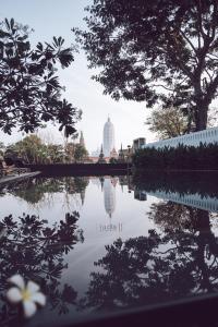 a reflection of a building in a pool of water at iuDia Hotel in Phra Nakhon Si Ayutthaya
