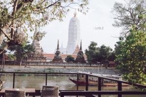 a boat in a river in front of a building at iuDia Hotel in Phra Nakhon Si Ayutthaya