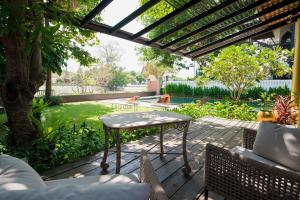 a patio with a table and chairs on a deck at iuDia Hotel in Phra Nakhon Si Ayutthaya