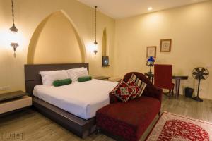 a bedroom with a bed and a red chair at iuDia Hotel in Phra Nakhon Si Ayutthaya
