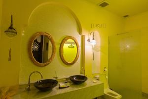 a bathroom with two sinks and two mirrors on the wall at iuDia Hotel in Phra Nakhon Si Ayutthaya