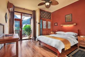 a bedroom with a large bed with red walls at Yangshuo Village Inn Boutique Hotel in Yangshuo +92 photos