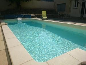 a large swimming pool with blue water at Les Lumieres d'Epernay in Épernay