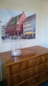 een glazen vaas op een houten dressoir bij Central Hotel in Freiburg im Breisgau