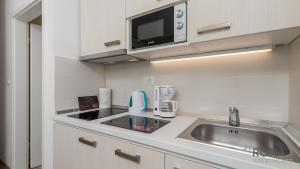 a kitchen with a sink and a microwave at Rona Studio Apartment Tena in Lovran +9 photos