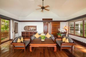 - un salon avec un canapé et une table dans l'établissement Napasai, A Belmond Hotel, Koh Samui, à Mae Nam Beach