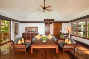 ein Wohnzimmer mit einem Sofa und einem Tisch in der Unterkunft Napasai, A Belmond Hotel, Koh Samui in Mae Nam