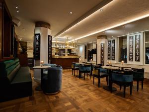 a restaurant with tables and chairs and a bar at Clayton Hotel Amsterdam American in Amsterdam