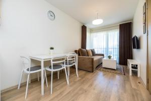 a living room with a table and chairs and a couch at Lunos apartamentai - Centras in Palanga