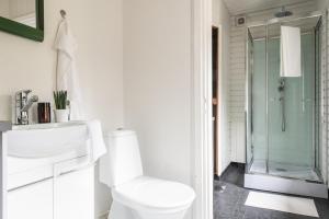 a white bathroom with a toilet and a shower at Kesäelo in Porvoo +11 photos