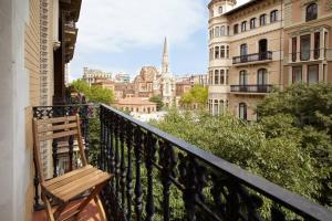 a bench on a balcony with a view of a city at Beautiful apartment in Eixample in Barcelona
