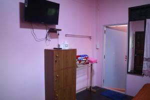 a room with a dresser and a television on a wall at Baanmakpoo บ้านหมากพลู in Sangkhla Buri