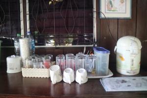 un mostrador con muchas licuadoras de vidrio sobre una mesa en Baanmakpoo บ้านหมากพลู en Sangkhla Buri