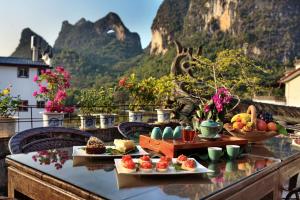 a table with food on it with a view of a mountain at Yangshuo Village Inn in Yangshuo