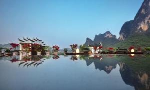 een zwembad met bergen op de achtergrond bij Yangshuo Village Inn in Yangshuo
