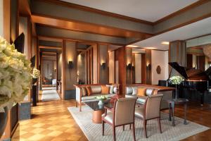 a living room filled with furniture and a piano at The Sukhothai Bangkok - SHA Plus Certified in Bangkok