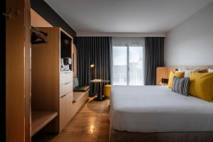 una camera d'albergo con un grande letto e una finestra di Hôtel Villa KOEGUI Bayonne a Bayonne