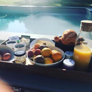 a tray of food with a bowl of fruit and a glass of orange juice at TinyHouse on the prairie in Mehaigne