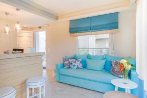 a blue couch in a living room with a window at Iliorama Luxury Apartments in Skala Potamias