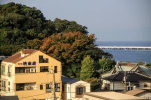 a building next to the water with a bridge in the background at Akitaya Annex in Kamakura