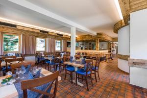 a restaurant with wooden tables and blue chairs at Hotel Blinnenhorn in Reckingen - Gluringen