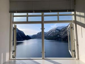 a window with a view of a lake and mountains at Vikinghaug in Odda